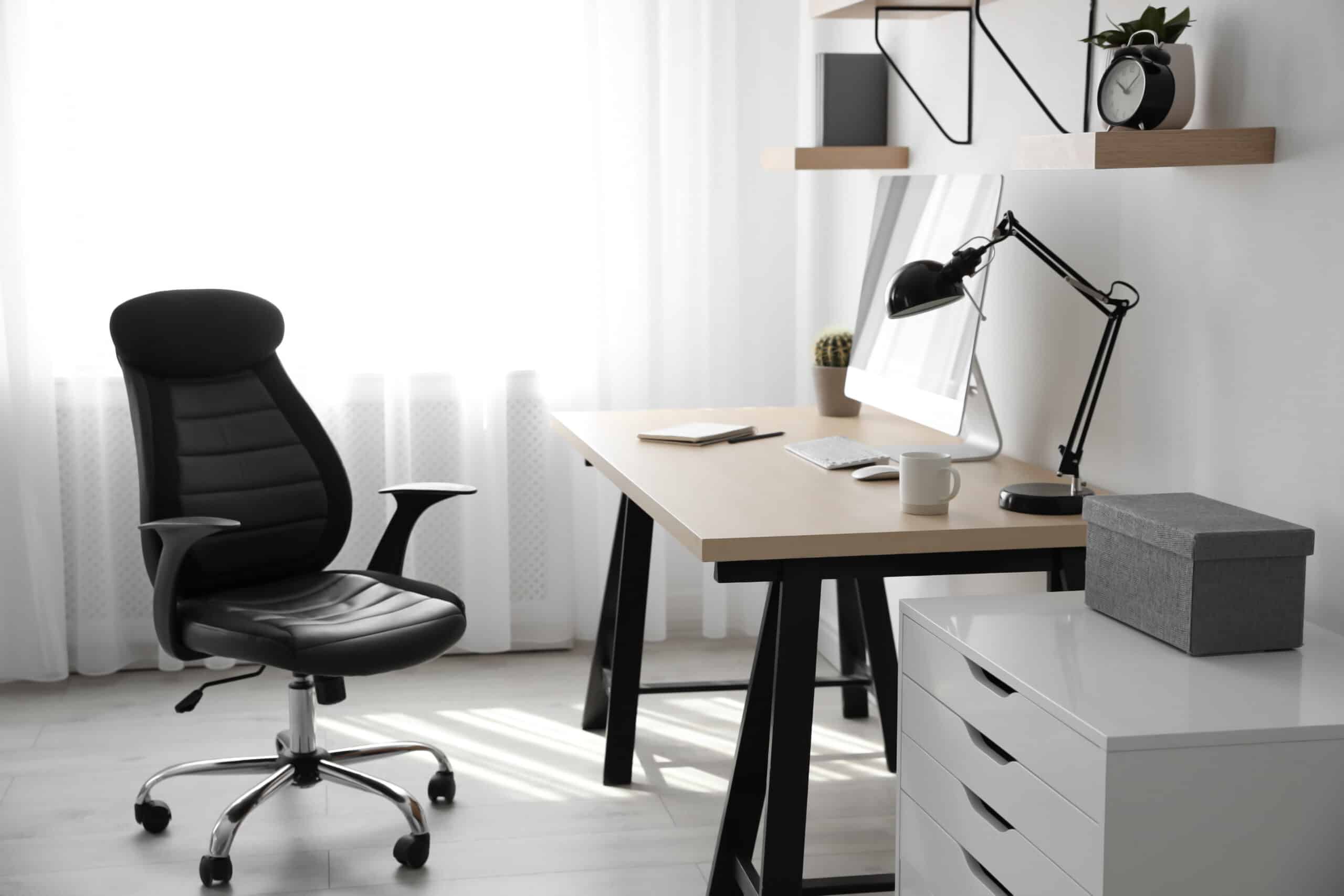 Comfortable office chair near table with modern computer